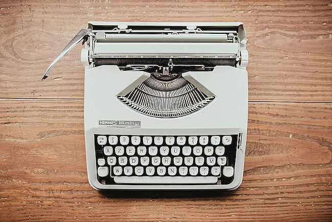 A mechanical typewriter. The lever for the carriage return is
on the outer left side.